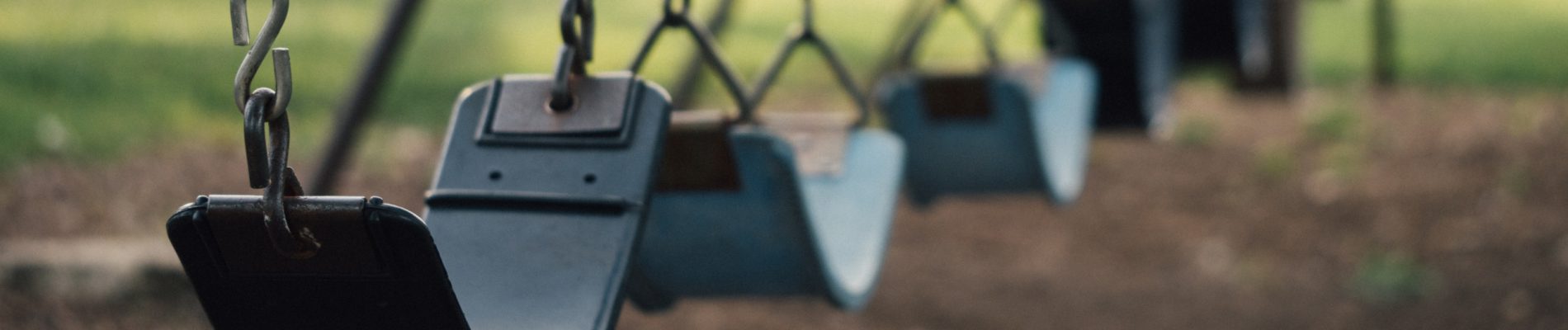 Une rangée de balançoires suspendues par des chaînes dans un parc.