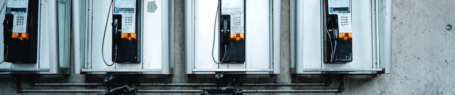 Plusieurs téléphones accrochés au mur.